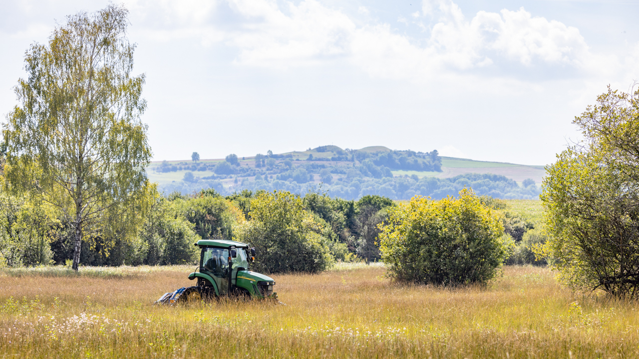 Traktor der Familie Fischer in einer Feuchtwiese Traktor fährt auf Feld