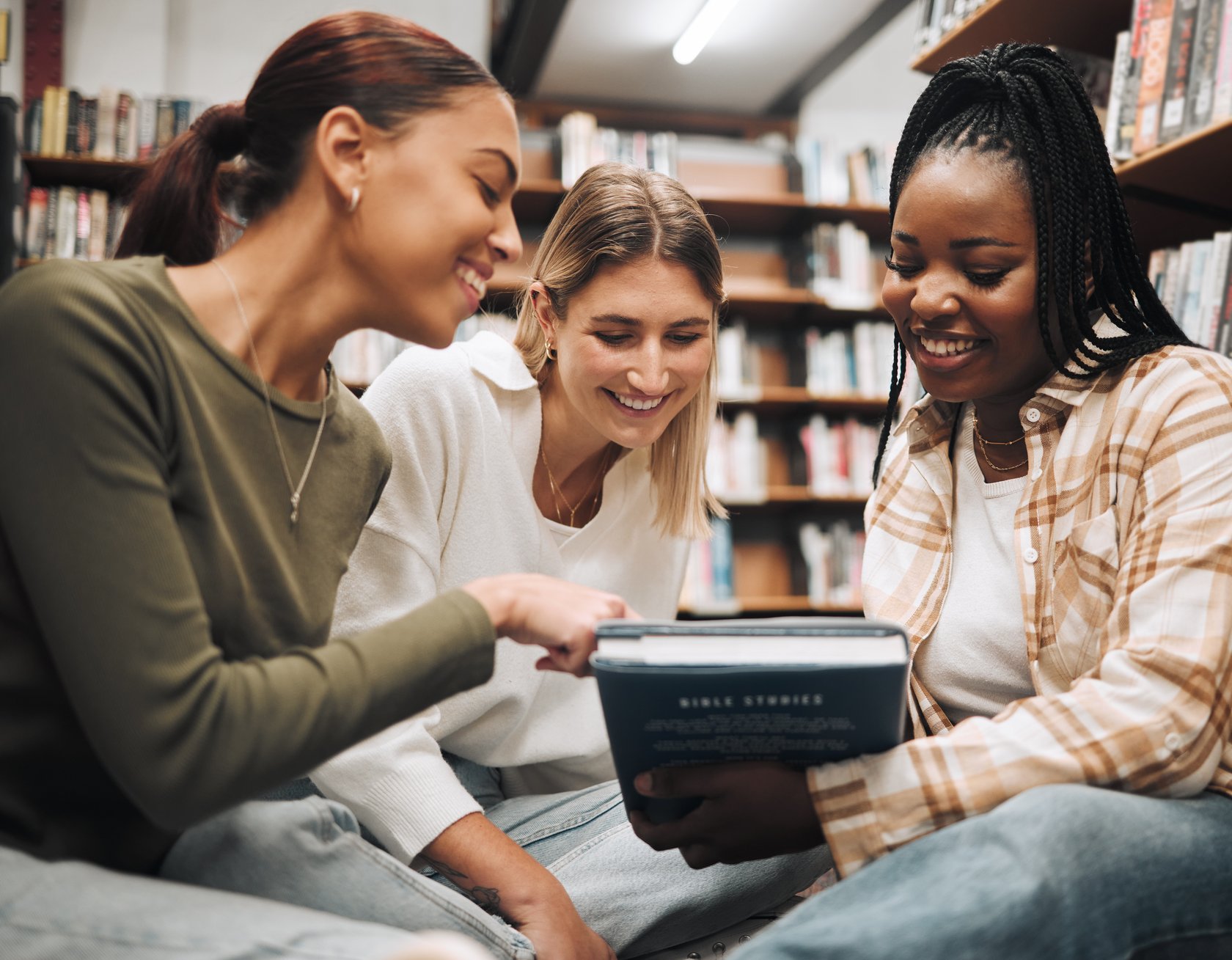 Aufgaben der Abteilung für Schule und Bildung Schülerinnen und Schüler sitzen um ein Buch