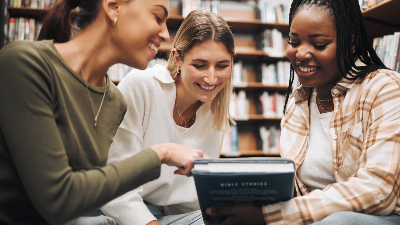Aufgaben der Abteilung für Schule und Bildung Schülerinnen und Schüler sitzen um ein Buch