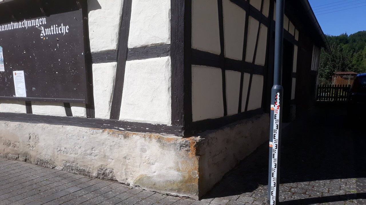 Eine Pegelanlage steht neben einem Fachwerkhaus 