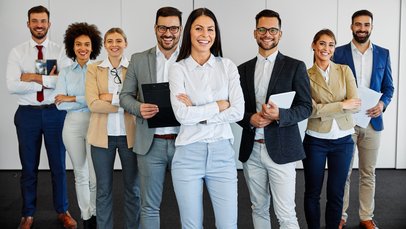 Lehrerinnen und Lehrer posieren gemeinsam vor einer Wand