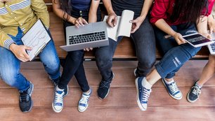 Schülerinnen und Schüler sitzen auf einer Treppe