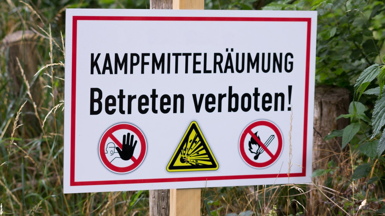 Warnschild Kampfmittel mit der Aufschrift "Kampfmittelräumung - Betreten verboten"