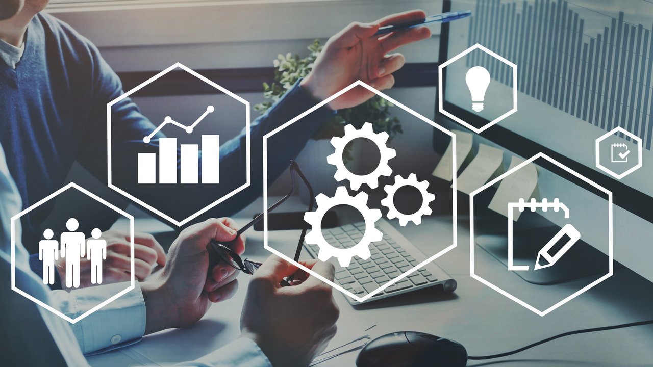 Digitalisierung im Büro - Frau arbeitet am Computer, darüber Symbole der Digitalisierung