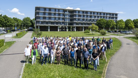 Mitarbeitende des RPs stehen vor einem der Dienstgebäude