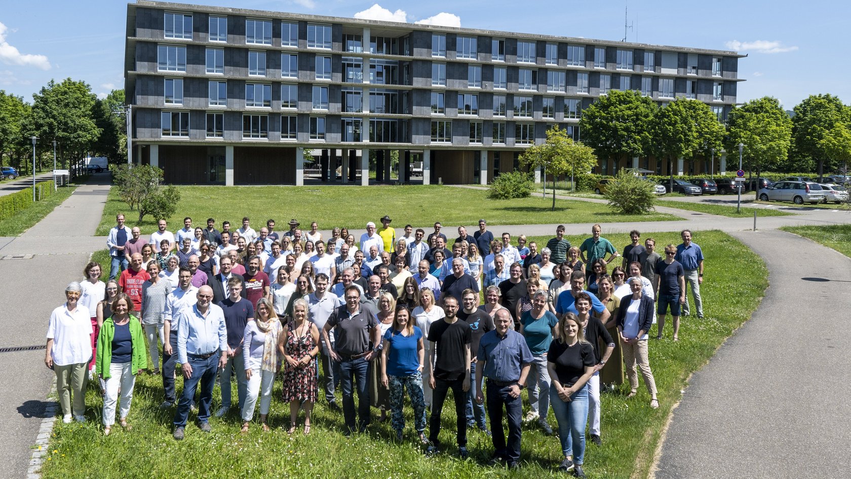 Mitarbeitende des RPs stehen vor einem der Dienstgebäude