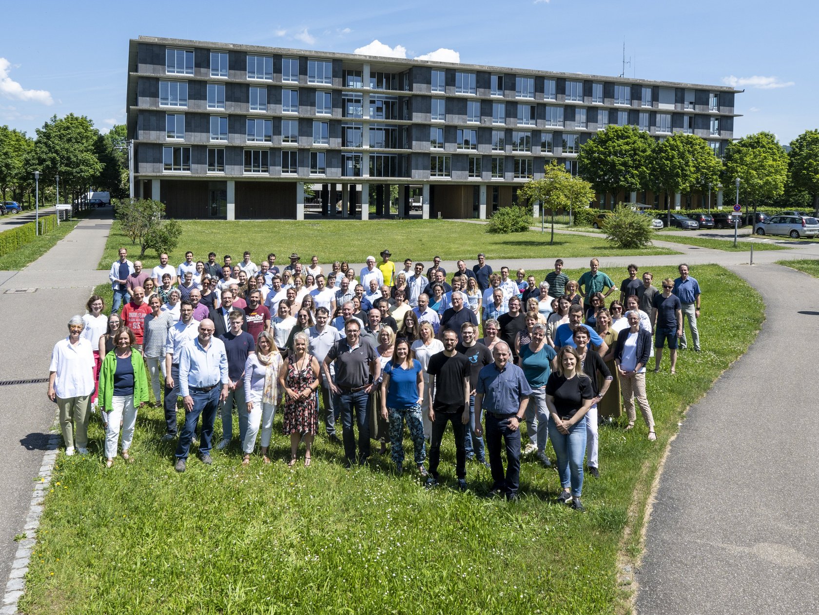 Mitarbeitende des RPs stehen vor einem der Dienstgebäude