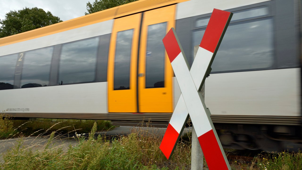 Zug fährt an einem Bahnübergang vorbei