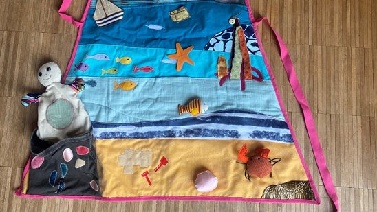 Bild zeigt eine Kochschürze aus Stoff mit Motiven aus dem Meer