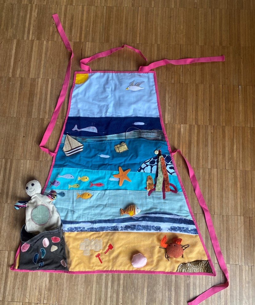 Bild zeigt eine Kochschürze aus Stoff mit Motiven aus dem Meer