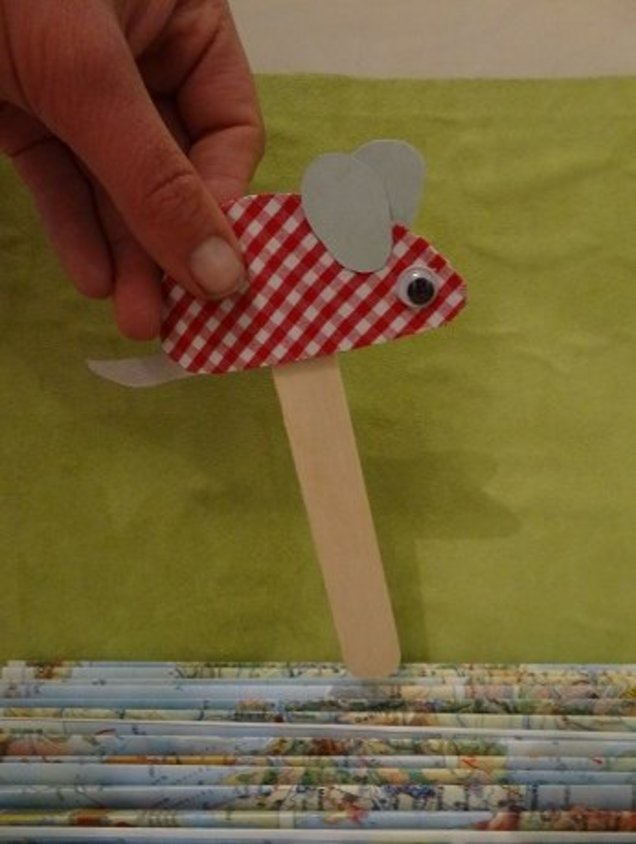 Eine gebastelte Maus wird in ein Buch gesteckt 