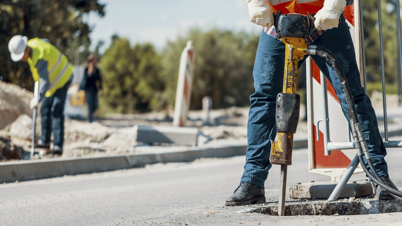 Eine Person mit einem Bohrhammer auf einer Straße