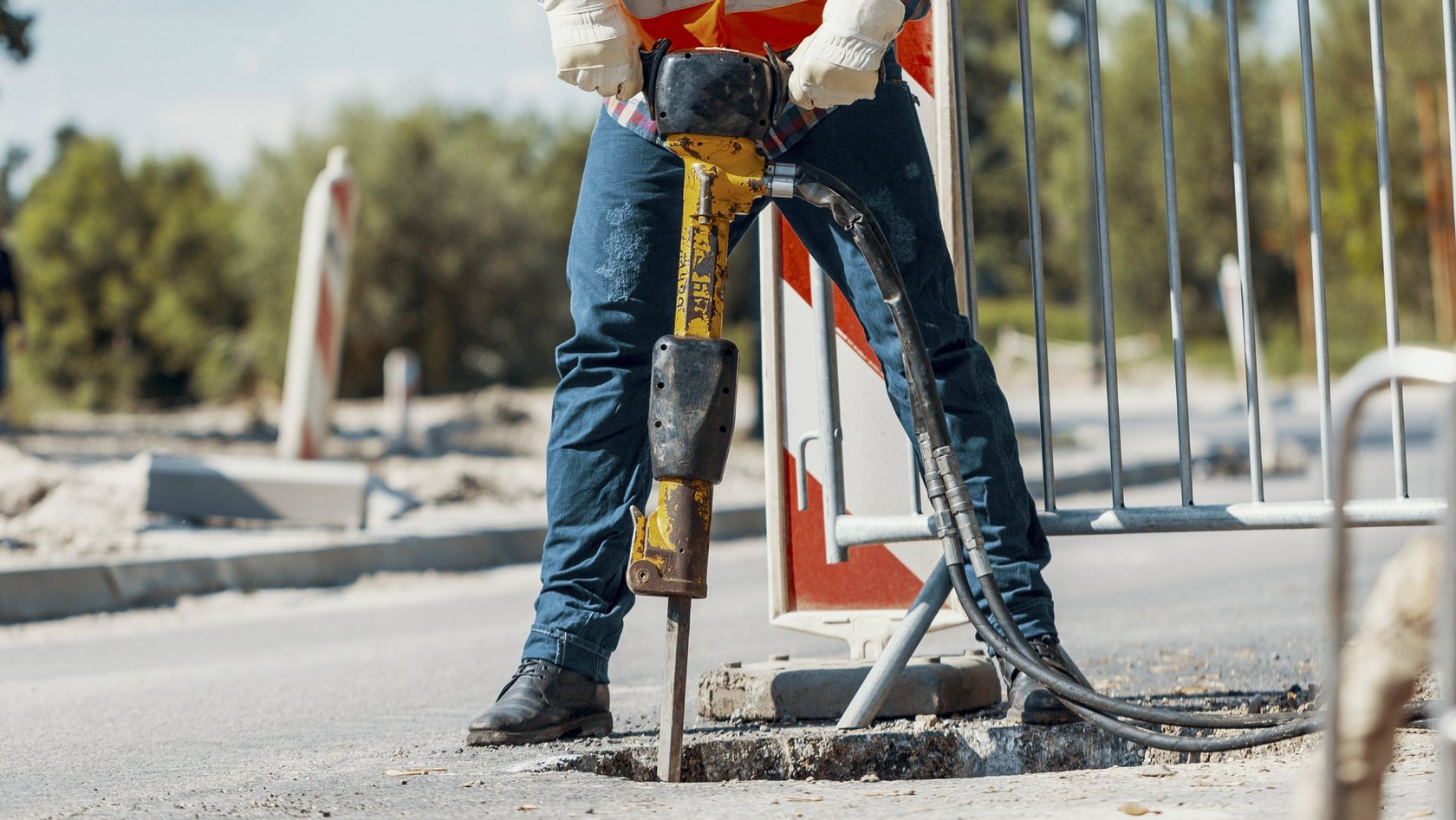 Eine Person mit einem Bohrhammer auf einer Straße