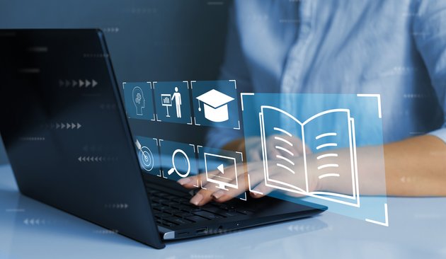 Person tippt auf Laptop, verschiedene Symbole schweben in der Luft (Dokumente, Ordner etc.)