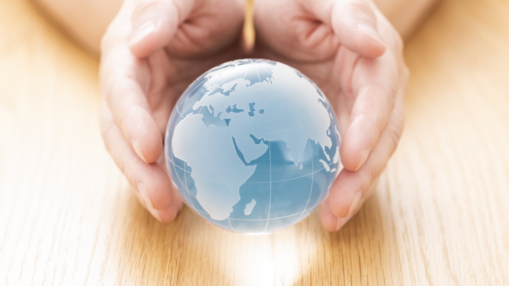 Ein Erdball wird in den Händen gehalten 