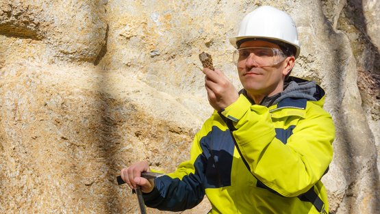 Ein Geologie untersucht eine Gesteinsschicht