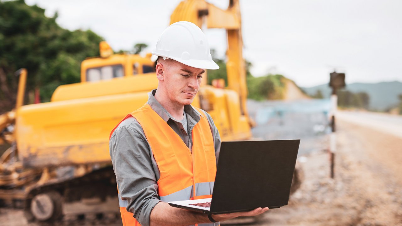 Referat 42 - Steuerung und Baufinanzen Ein Ingenieur mit einem Laptop auf der Baustelle