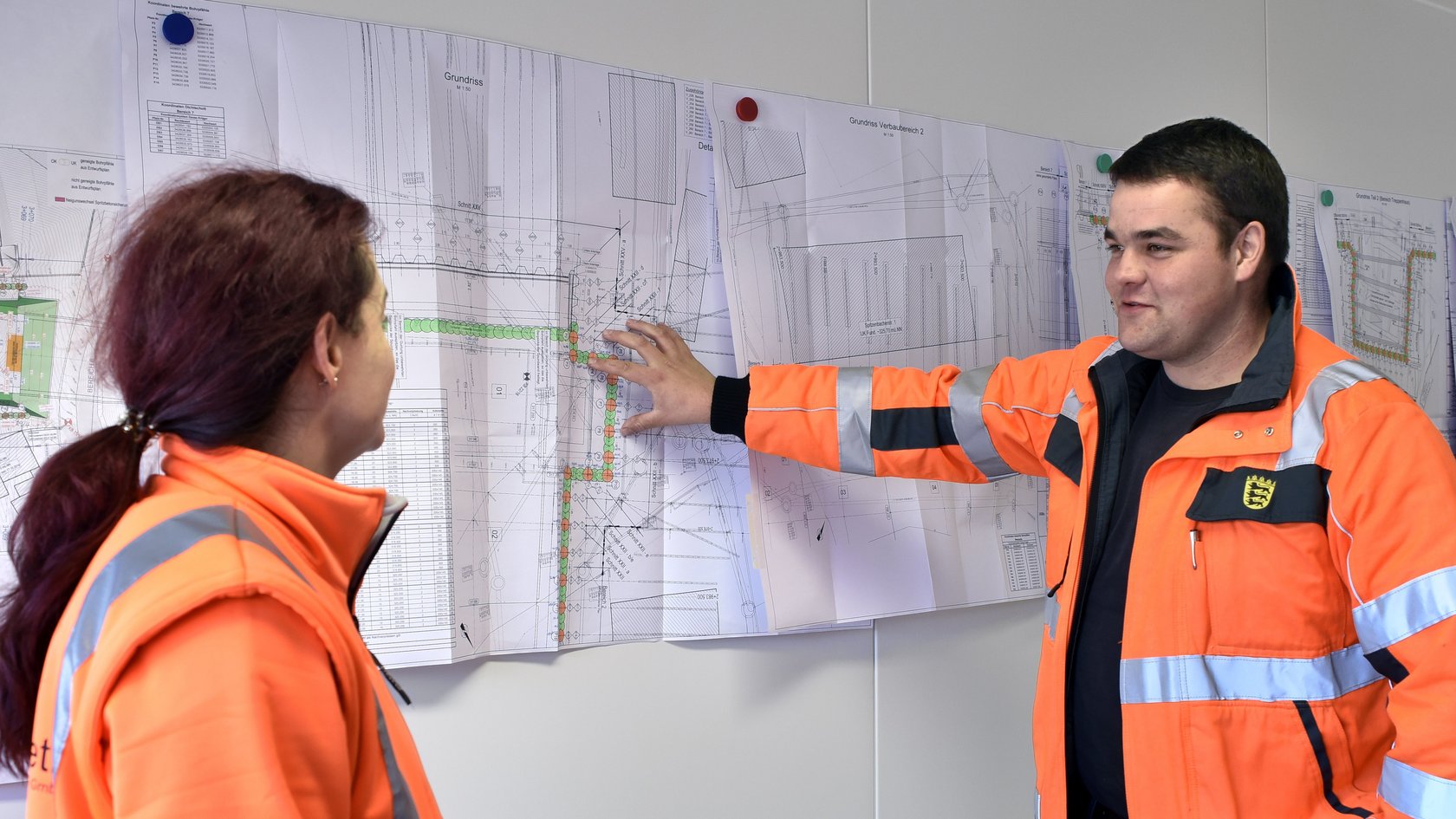 Ein Student zeigt auf Pläne