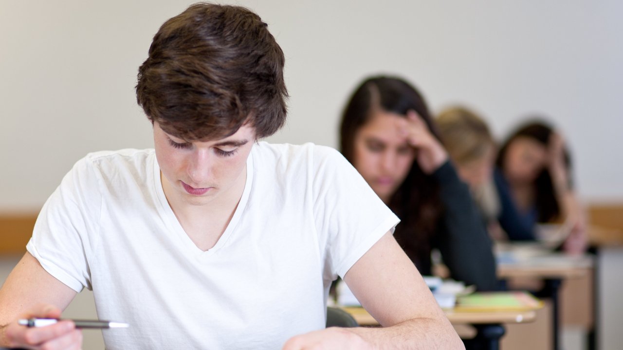 Mehrere Schülerinnen und Schüler sitzen im Klassenraum