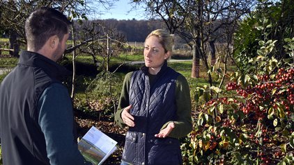Arbeiten im Regierungspräsidium Freiburg Zwei Personen im Gespräch vor einer landwirtschaftlichen Fläche