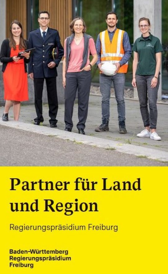 Mitarbeitende des RPs stehen auf der Wiese vor dem Dienstgebäude des RPs in der Bissierstraße