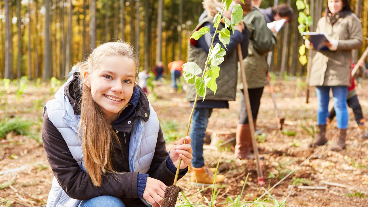 Ein Mädchen pflanzt einen Baum