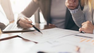 Verträge und eine unterschreibende Hand