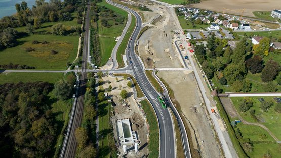 Luftbild der gesamten Baustelle: Um überschüssiges Wasser aus dem Boden zu pressen, wird bei der „Vorkonsolidierung“ die auf dieser Ansicht nicht bewachsene Fläche in der Bildmitte mit Erdmassen belastet