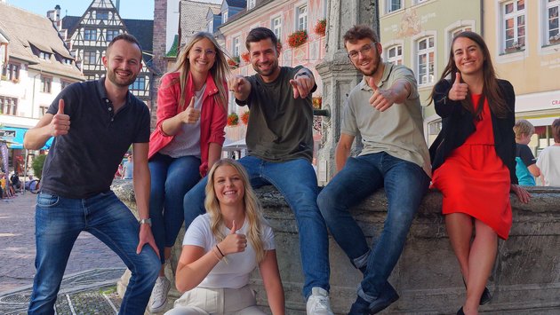 Mitarbeiterinnen und Mitarbeiter des Regierungspräsidium vor einem Brunnen in der Freiburger Innenstadt