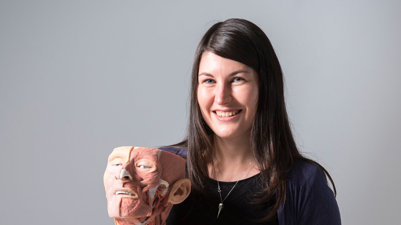 Eine Frau hält einen Oberkörper aus dem 3D-Drucker in der Hand