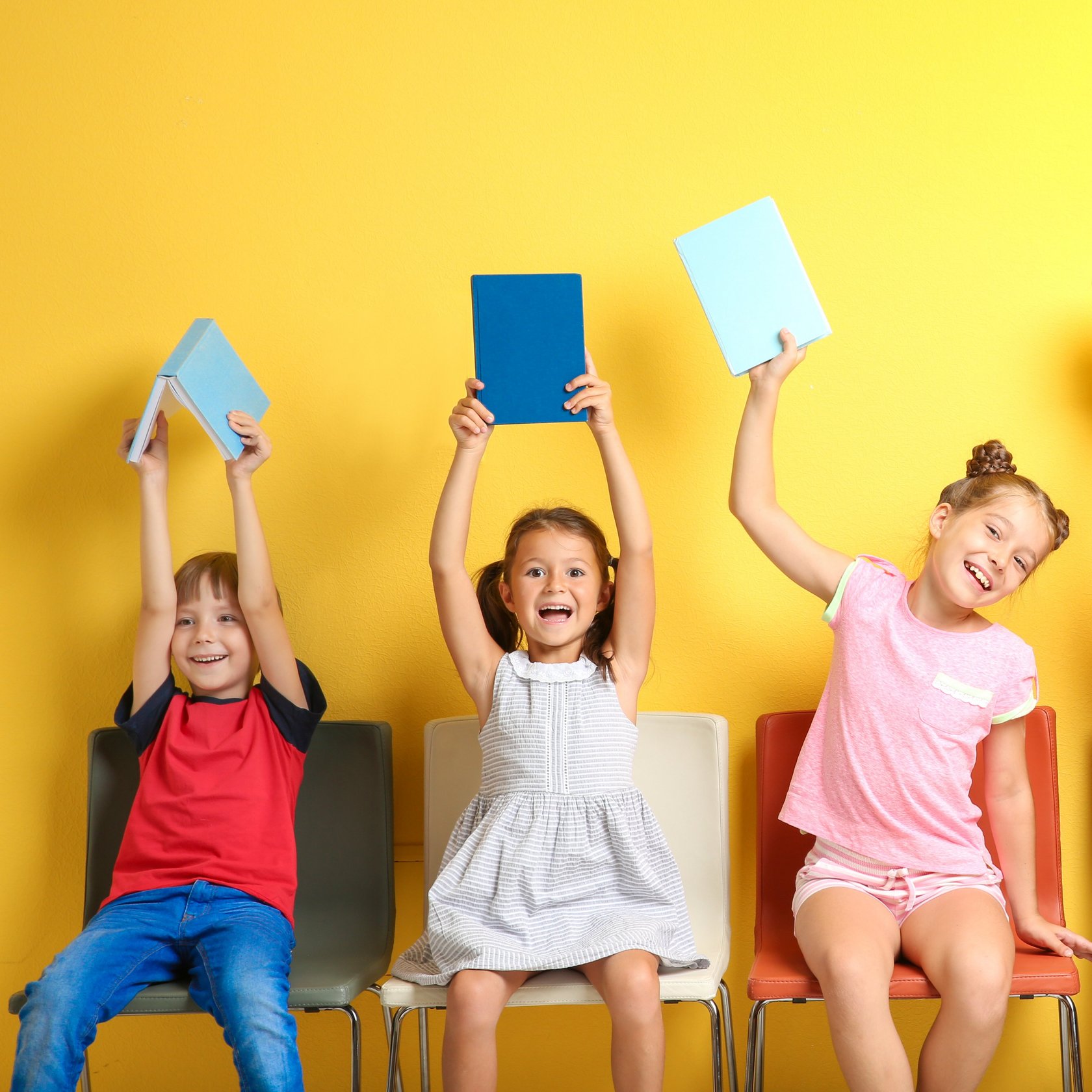 Kinder halten Bücher hoch