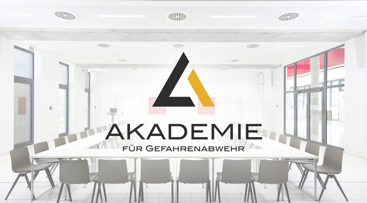 In U-Form bestuhlter Seminarraum der Akademie mit überblendetem Logo