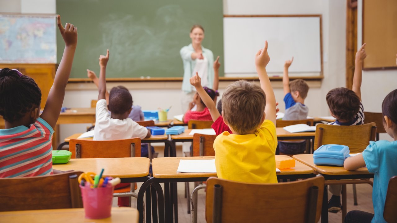 Klassenraum mit Kindern, die sich melden