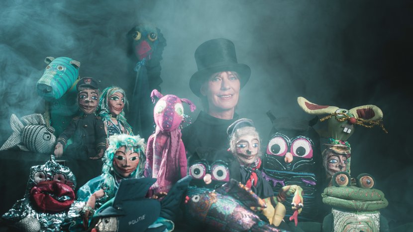 Bild zeigt Marionetten und eine Puppenspielerin