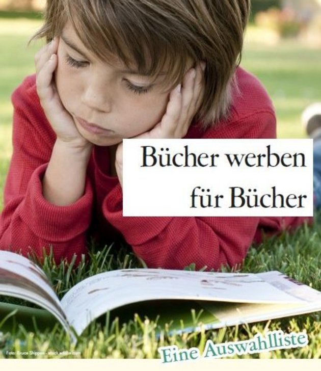 Junge liegt im Gras und liest ein Buch