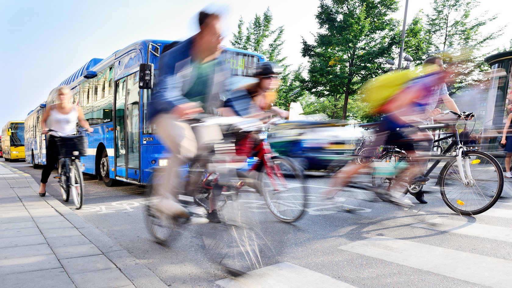 Fahrradfahrerinnen und -fahrer vor Bus und Auto